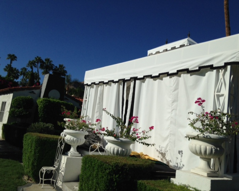 White fabric cabana with roof and side curtains
