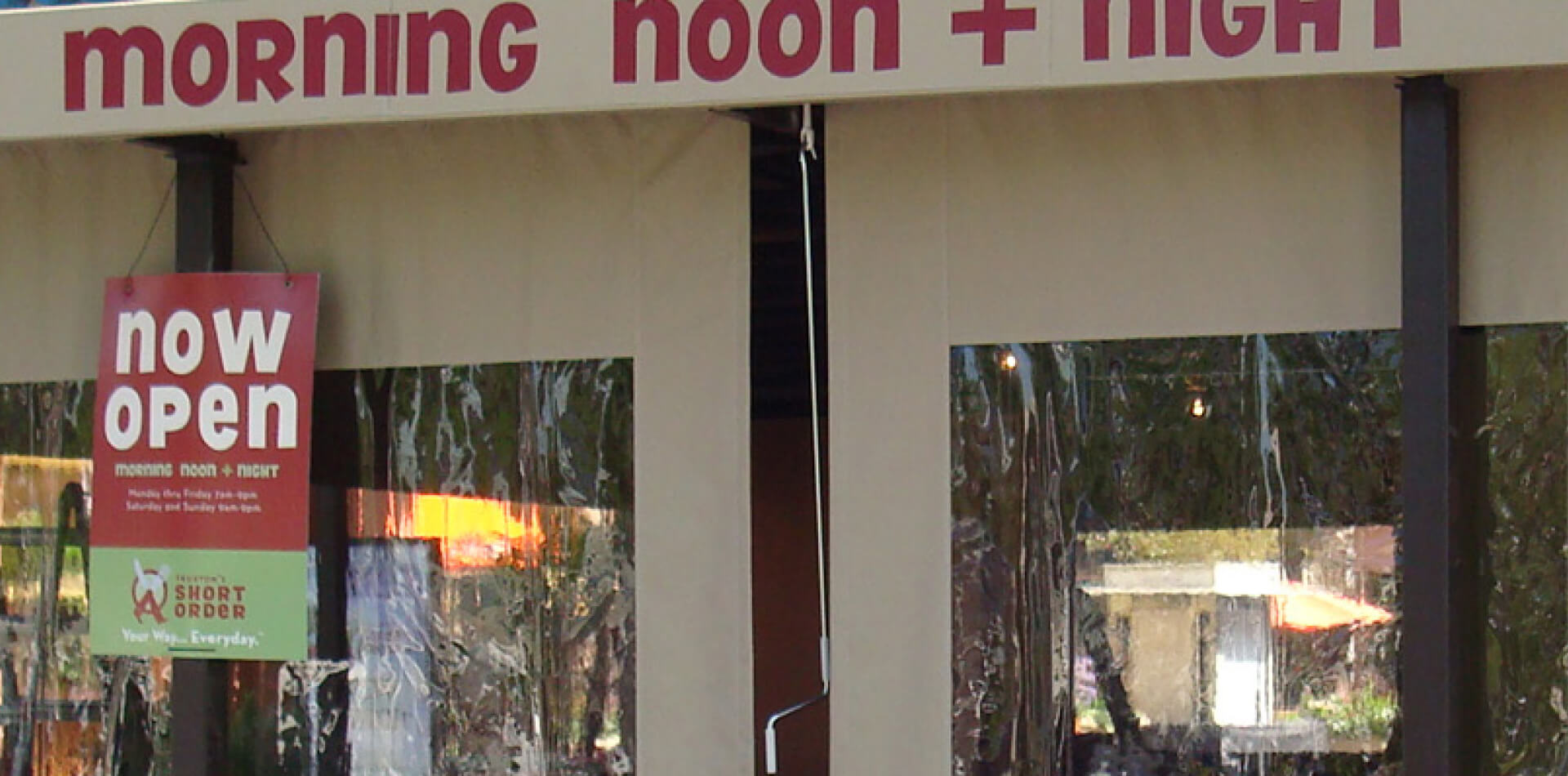 Tan outdoor drop-down shades lowered across a restaurant patio